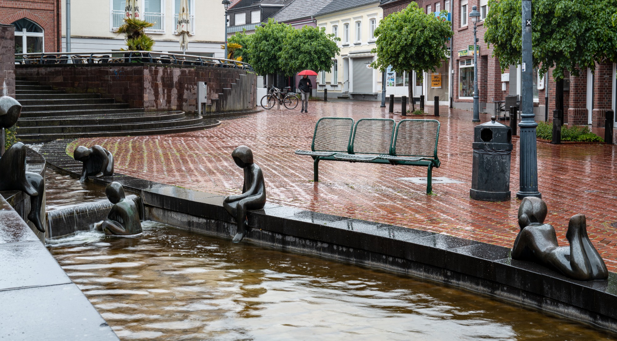 Im Regen mit rotem Schirm
